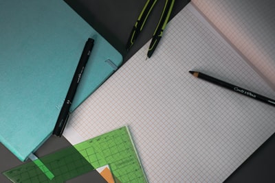 Black click pen next to the green paper
